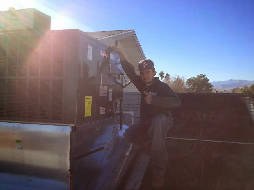HVAC technician performing Air Duct Cleaning on a rooftop unit in Fairfield